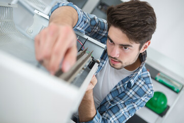 closeup shot young male technician repairing digital photocopier machine