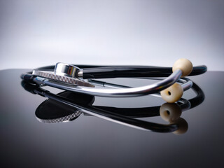 Closeup stethoscope with reflection on a black acrylic board