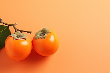 Close up view of persimmons on orange colour background.
