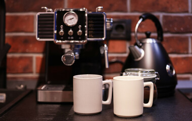 Morning coffee. Close up photo with a vintage coffee machine preparing an espresso drink in a white ceramic pot. Working from home environment in an industrial kitchen decor.