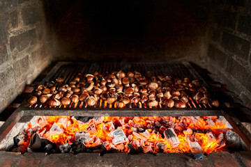 Brown chestnuts are roasted on hot coals on the grill