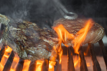 Grilled meat steak on stainless grill with flaming, Food and cuisine concept.