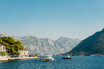 Pleasure boats are moored near the coast of Perast at the foot of the mountains. Montenegro