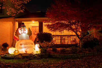 Glowing outdoor inflatable turkeys figures in the hat with inscription - Happy Thanksgiving next to...