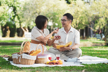 Happy asian middle aged couple in love on a romantic date outdoors in the summer at the park.