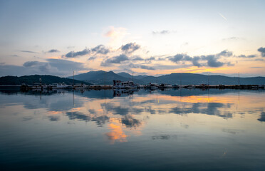 Sunrise sky and cloud reflection on still sea.