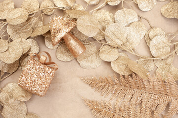 Fototapeta na wymiar Sparkling festive background, shimmering gold leaves and ornaments. Gift and mushroom