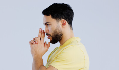 Finger gun, pointing and profile of man in studio with aim for target, shooting and spy on blue background. Secret agent, mockup space and face of person with hand gesture for pistol or weapon