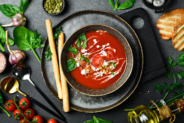 Vegan Tomato soup with basil and cream. In a bowl. The concept of vegetarian food.