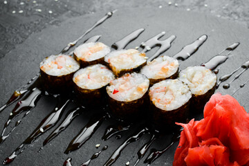 Classic maki rolls. On a black stone background. Top view.