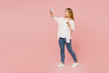 Full body side view young woman wear shirt white t-shirt casual clothes doing selfie shot on mobile...
