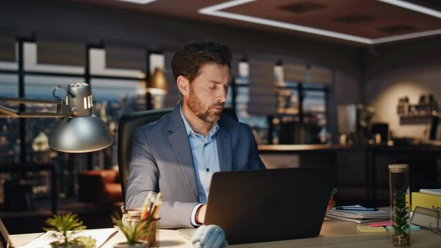 Handsome businessman checking smartphone at dark workplace closeup. Man reading