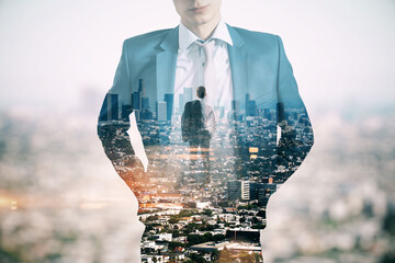 Young european businessman standing on abstract city background. Success, future and ceo concept....