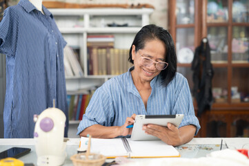 A woman is planning to design a sewing kit on her home sewing machine. Female seamstress working on a sewing machine