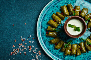 Traditional delicious Turkish foods: dolma (sarma) stuffed grape leaves rice. Close up. On a dark background. - obrazy, fototapety, plakaty