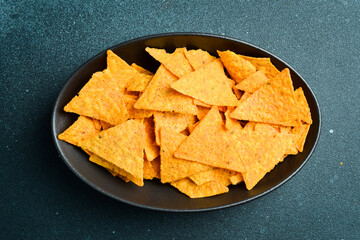 Bowl of Mexican nachos chips. Tortilla chips. Taco chips in a black bowl. Corn chips. Top view.