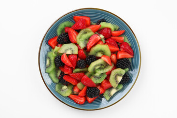 Plate of yummy fruit salad on white background, top view
