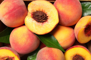 Delicious juicy ripe peaches and green leaves, flat lay