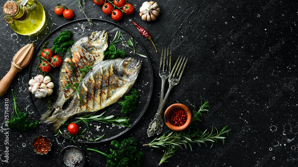 Wall mural grilled dorado fish with spices and vegetables. on a black background. photo for the menu.