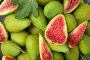 Cut and whole green figs as background, top view.