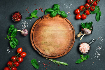 Round kitchen cutting board. On a black stone background. Top view.