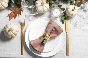 Beautiful autumn table setting. Plates, cutlery, glasses, pumpkins and floral decor, flat lay