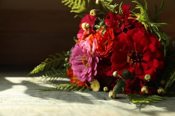 Bouquet of beautiful wild flowers on wooden rustic table against dark background. Space for text