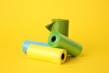 Colorful dog waste bags on yellow background