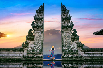 Young woman standing in temple gates at Lempuyang Luhur temple in Bali, Indonesia. - obrazy, fototapety, plakaty