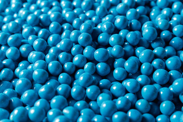 Closeup blue dragee, chocolate covered nuts, sweet candy background
