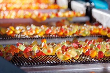 Closeup color jelly fruit on conveyor line of plant. Concept production manufacture food marmalade