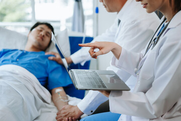 Fototapeta premium Two doctors talking to a patient lying in his bed with receiving saline solution in a hospital