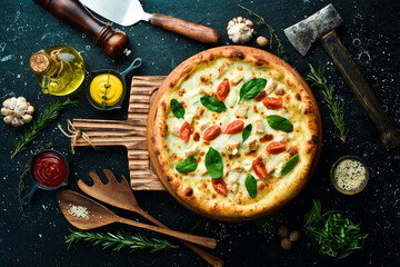 Pizza with chicken, tomatoes and spinach. classic pizza On a black stone background. Top view.