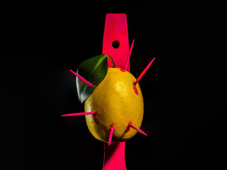 Composition with lemon and arrows on a black background