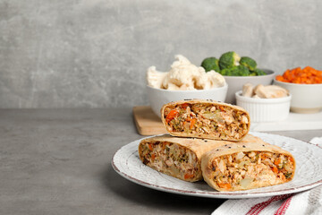 Pieces of delicious strudel with chicken, vegetables and products on light grey textured table, closeup. Space for text