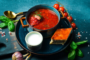 Homemade borsch with sour cream. Beet soup. Ukrainian cuisine. Close up. On a dark stone background.