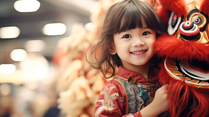 Litter caucasian girl in Chinese costume with a Chinese lion in the Chinese new year