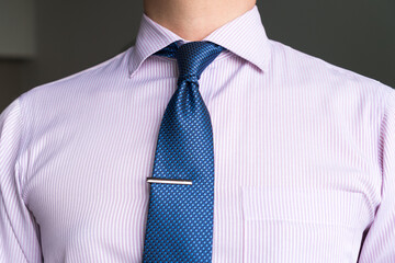 Navy blue necktie is tied in Prince Albert or Double-Four-In-Hand knot with single dimple and tie...
