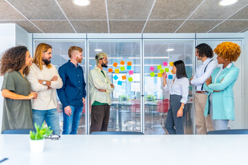 Coworkers using colorful adhesive notes with ideas during a brainstorming