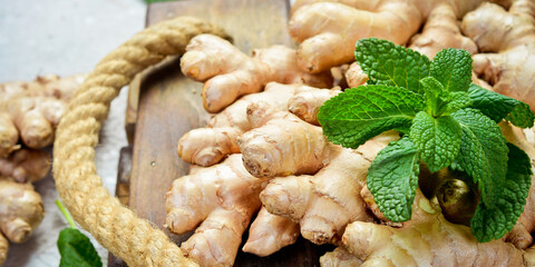 Fresh ginger and green mint. Free space for text, on stone background.
