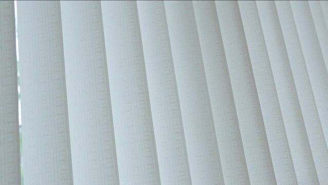 Vertical light blinds, curtains made of thick fabric, protect against light from the window.
