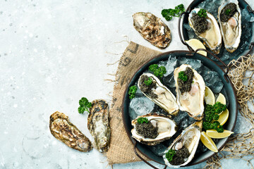 A plate of Fresh oysters with black sturgeon caviar lemon and ice. Restaurant delicacy. oysters...
