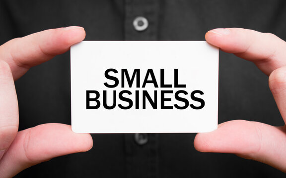 Businessman holding a card with text SMALL BUSINESS , business concept