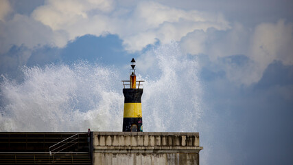 
wave breaks against the lighthouse