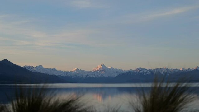 Vibrant sunset time lapse over Lake Pukaki and Mount Cook; tussock bushes in foreground