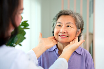 asian senior woman smile when cosmetologist touching her face to check her facial skin condition for cosmetic treatment at aesthetic clinic