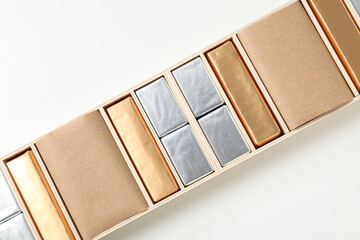 Chocolate candies in box on white background, top view