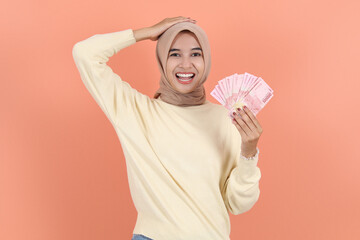 howing cash money in Indonesian rupiah banknotes and holding head.