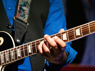 Fototapeta na wymiar les mains d'un guitariste jouant de son instrument