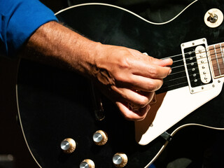 les mains d'un guitariste jouant de son instrument